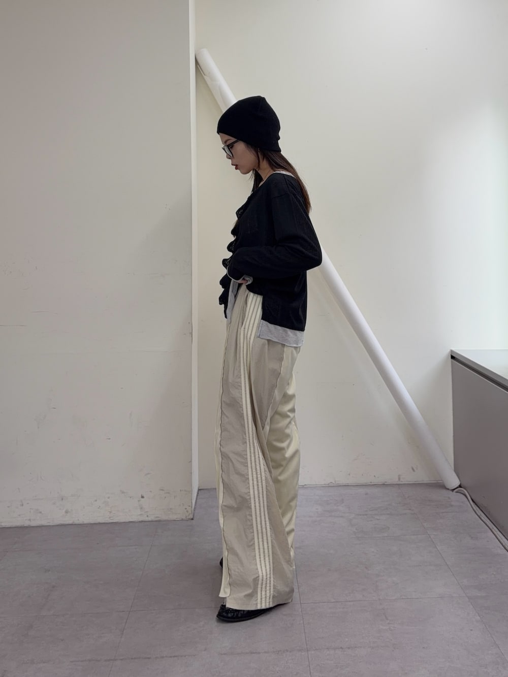 ブラック系のカーディガン/ボレロ、ホワイト系のスウェットパンツ、ブラック系のローファーを着用したレディースの冬コーディネートの2枚目の写真