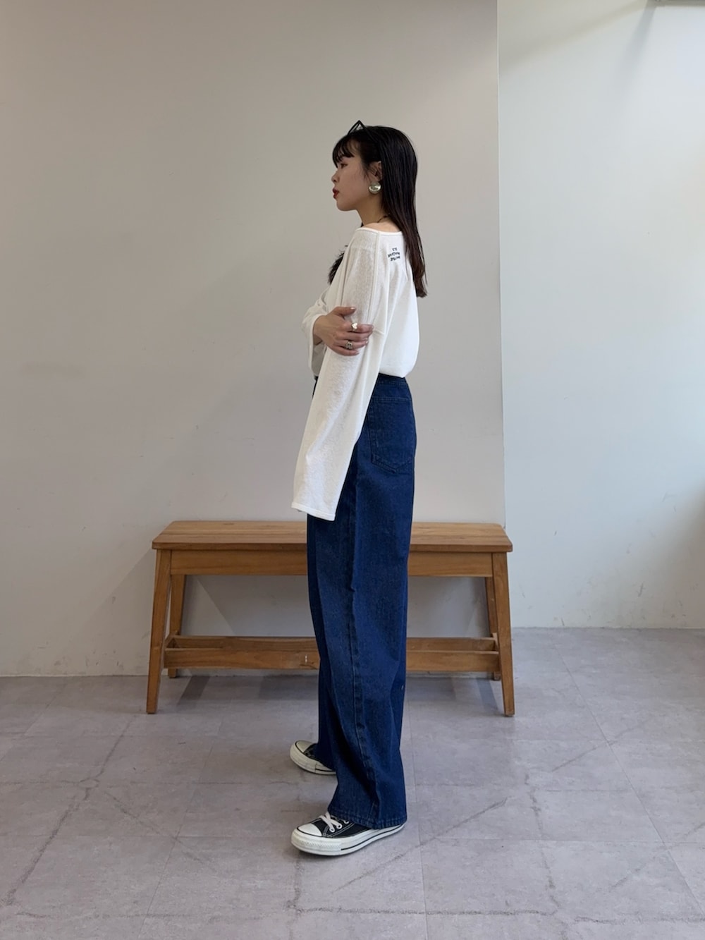 ホワイト系のTシャツ/カットソー、ブルー系のデニムパンツ、ブラック系のベルトを着用したレディースの春コーディネートの2枚目の写真