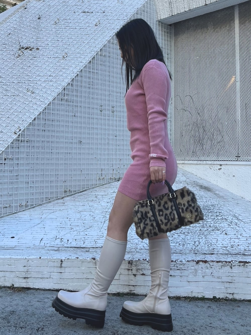 ピンク系のワンピース、ブラック系のボストンバッグ、ブラック系のブーツを着用したレディースの冬コーディネートの2枚目の写真