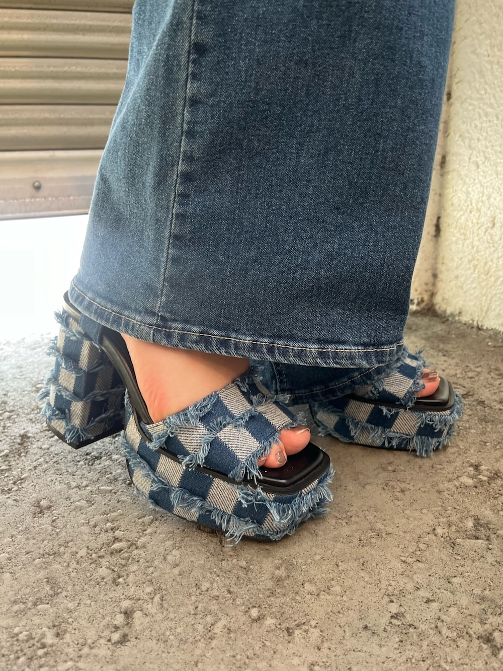 ブラック系のワンピース、ホワイト系のハンドバッグ、ブルー系のサンダルを着用したレディースの夏コーディネートの6枚目の写真