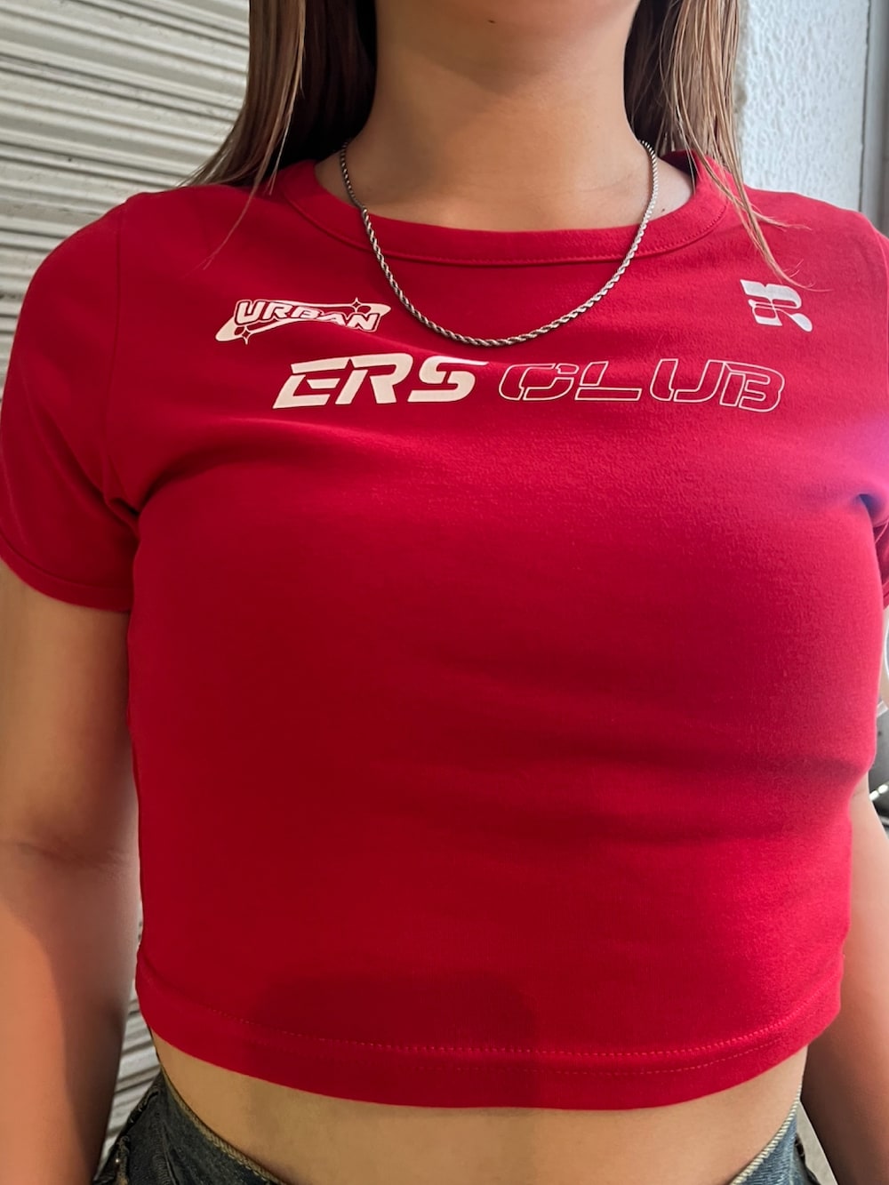 レッド系のTシャツ/カットソー、ホワイト系のハンドバッグ、ブラック系のサンダルを着用したレディースの夏コーディネートの4枚目の写真