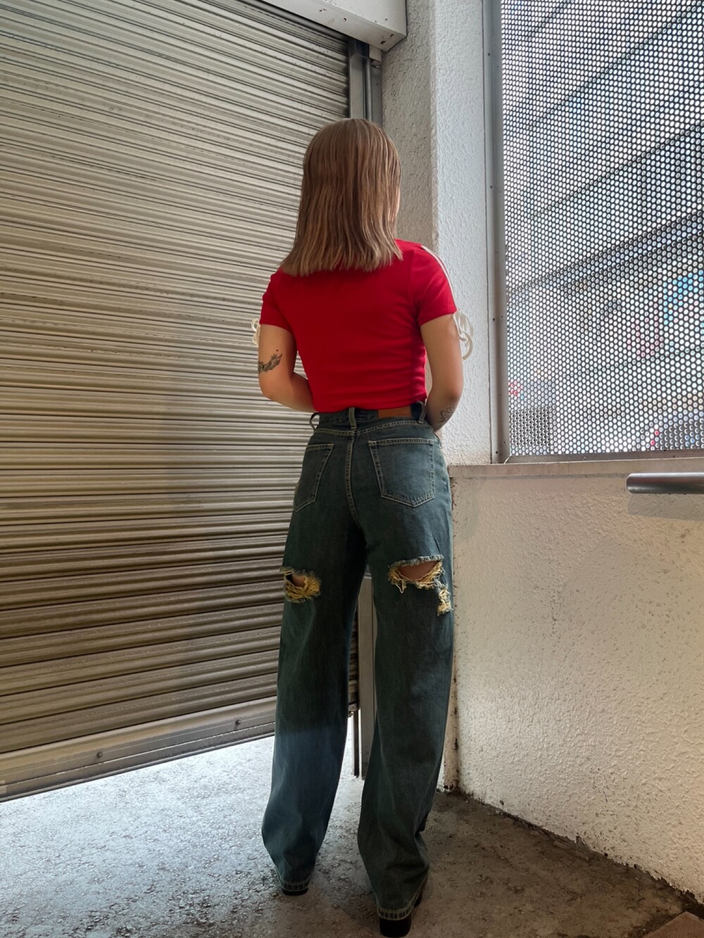 レッド系のTシャツ/カットソー、ホワイト系のハンドバッグ、ブラック系のサンダルを着用したレディースの夏コーディネートの3枚目の写真