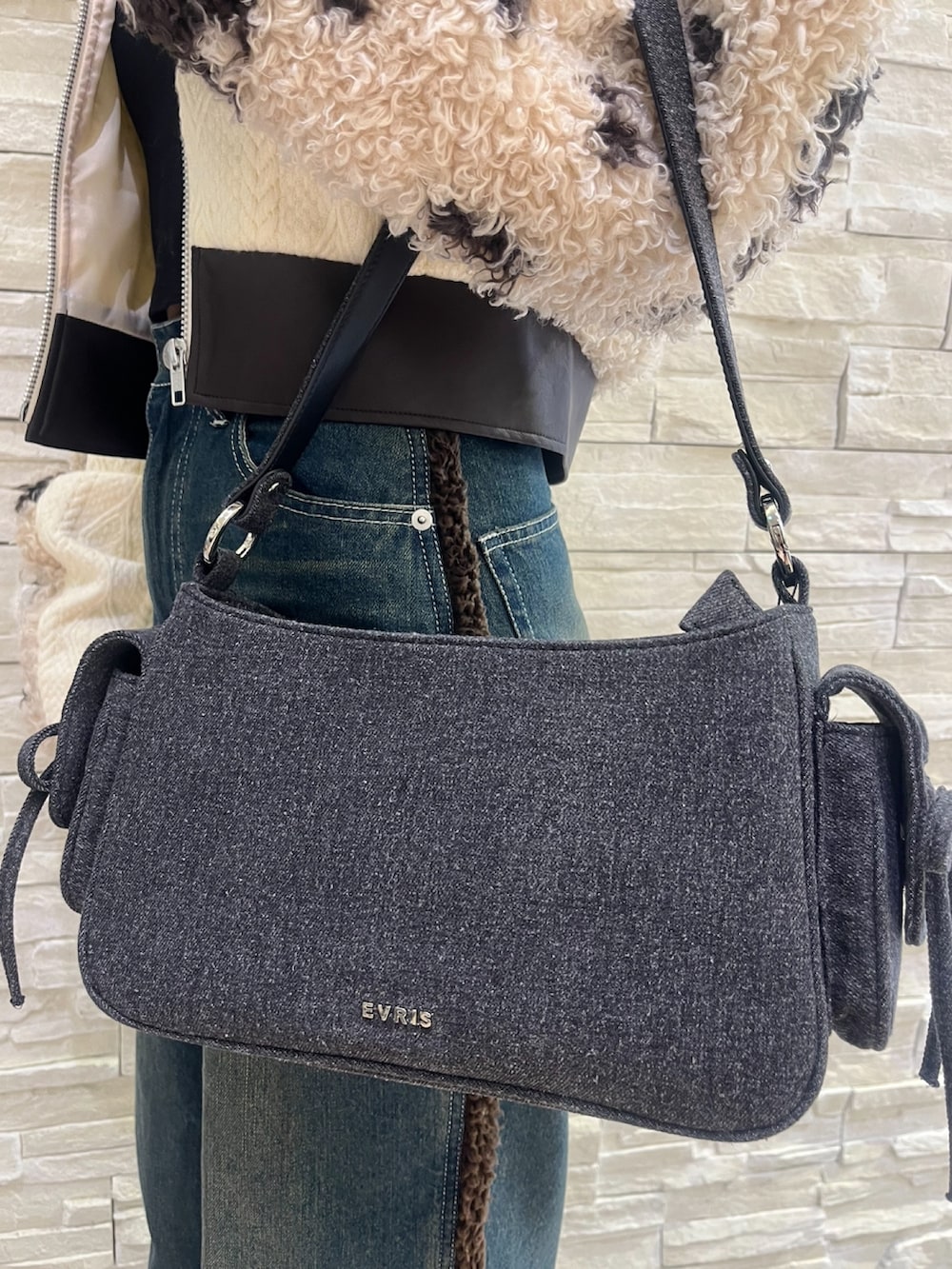 ブラウン系のブルゾン、ブルー系のデニムパンツ、ブラック系のハンドバッグを着用したレディースの秋コーディネートの7枚目の写真