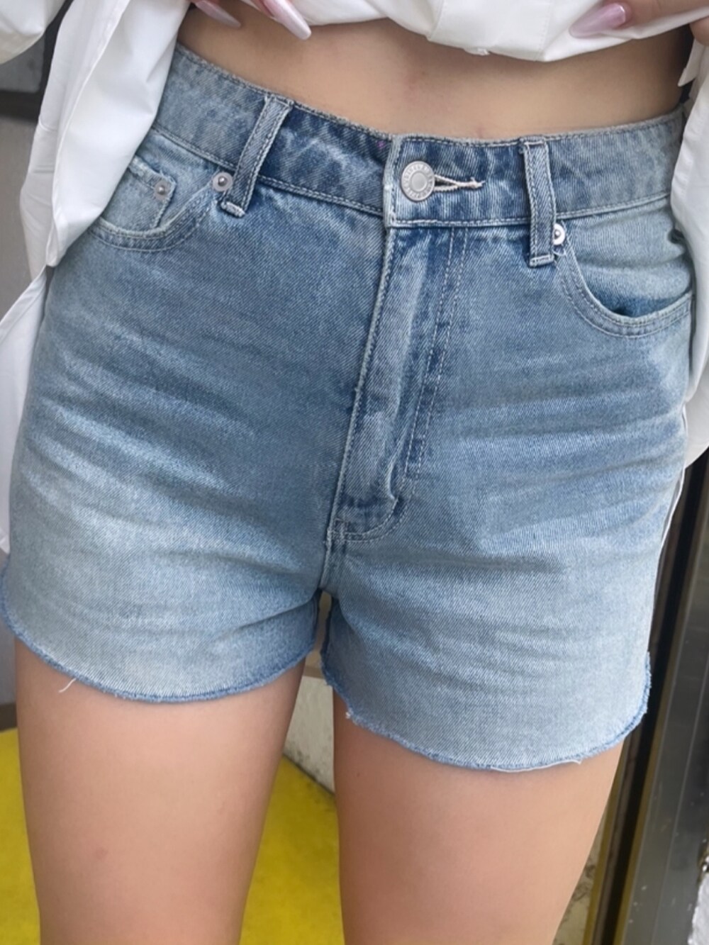 ホワイト系のシャツ/ブラウス、ブルー系のデニムパンツ、ブラック系のブーツを着用したレディースの夏コーディネートの7枚目の写真