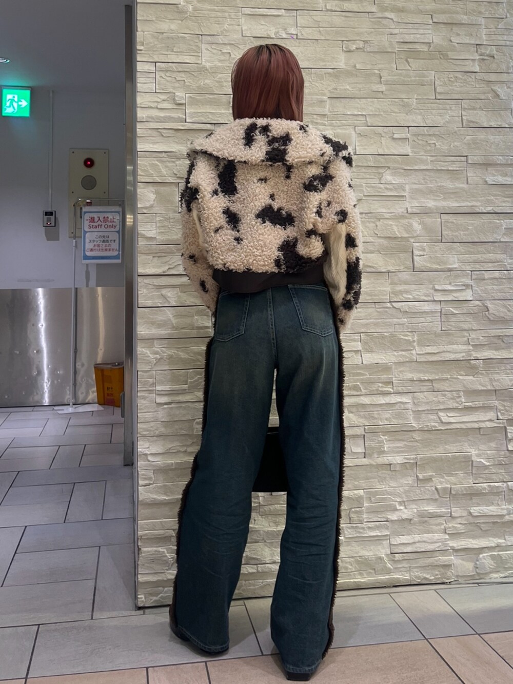 ブラウン系のブルゾン、ブルー系のデニムパンツ、ブラック系のハンドバッグを着用したレディースの秋コーディネートの3枚目の写真