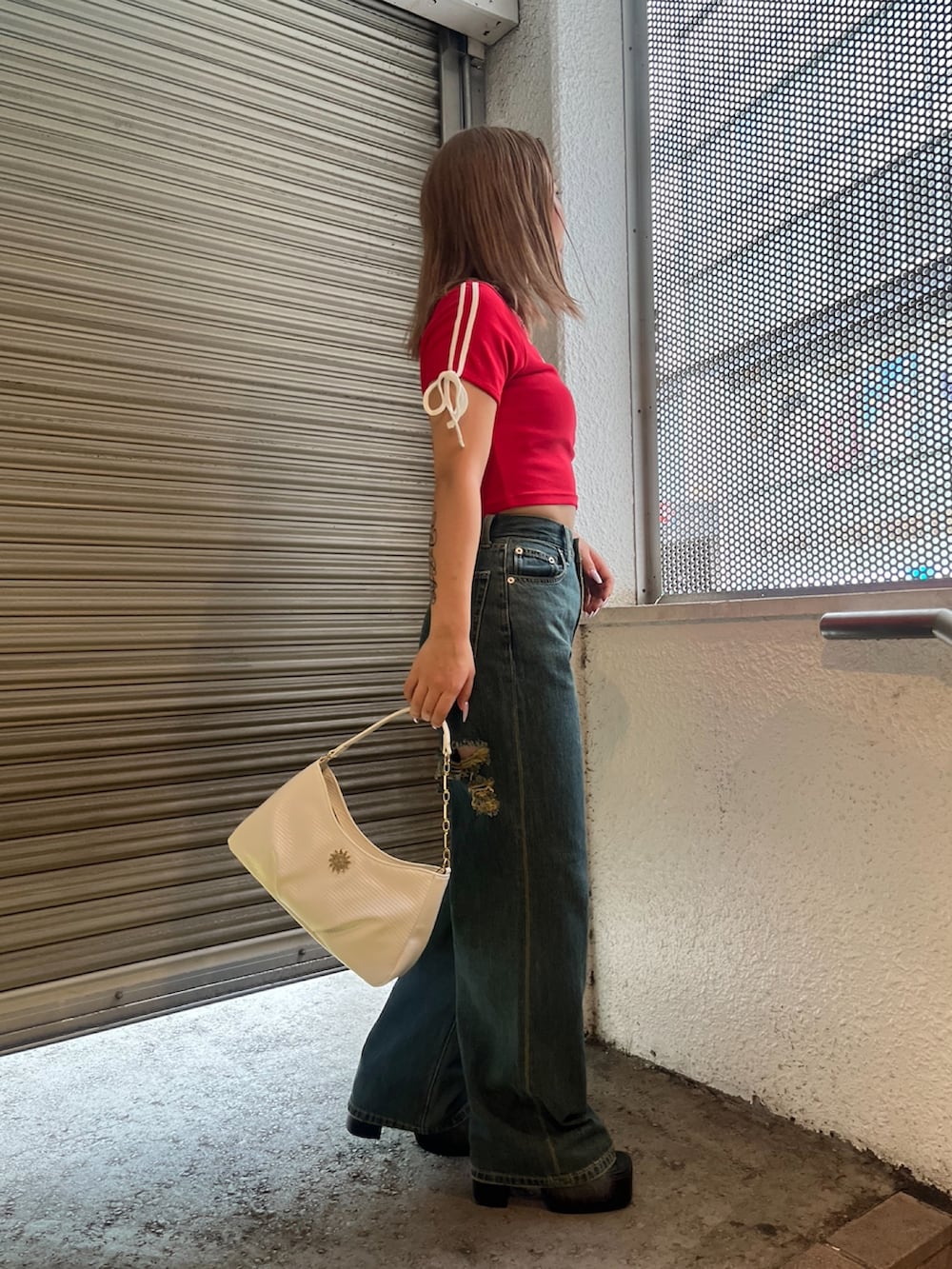 レッド系のTシャツ/カットソー、ホワイト系のハンドバッグ、ブラック系のサンダルを着用したレディースの夏コーディネートの2枚目の写真
