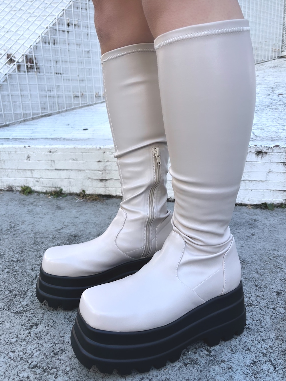 ピンク系のワンピース、ブラック系のボストンバッグ、ブラック系のブーツを着用したレディースの冬コーディネートの6枚目の写真