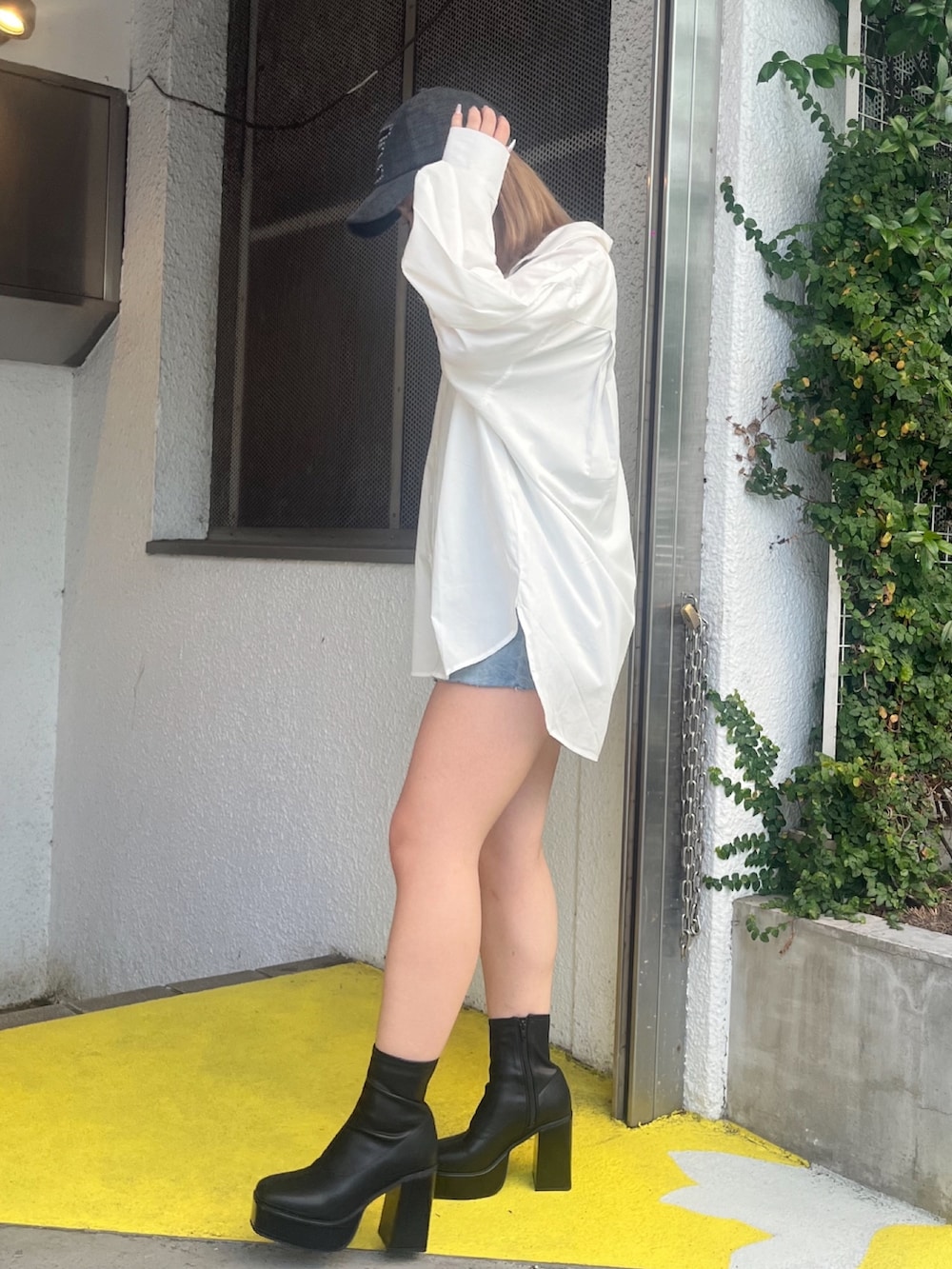 ホワイト系のシャツ/ブラウス、ブルー系のデニムパンツ、ブラック系のブーツを着用したレディースの夏コーディネートの2枚目の写真
