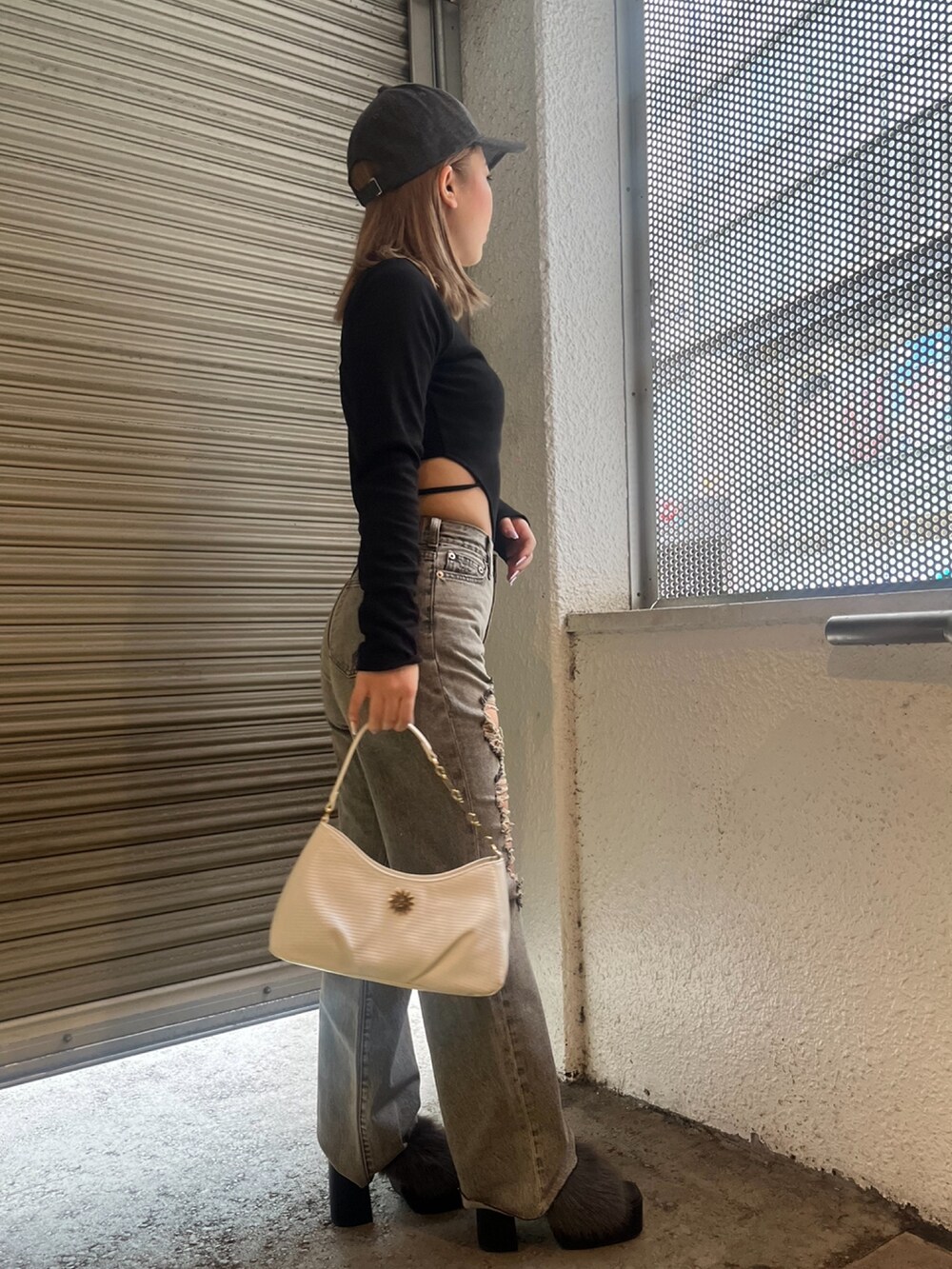 ブラック系のTシャツ/カットソー、ホワイト系のハンドバッグ、ブラック系のサンダルを着用したレディースの夏コーディネートの2枚目の写真