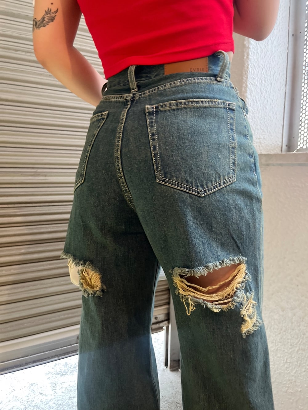 レッド系のTシャツ/カットソー、ホワイト系のハンドバッグ、ブラック系のサンダルを着用したレディースの夏コーディネートの6枚目の写真