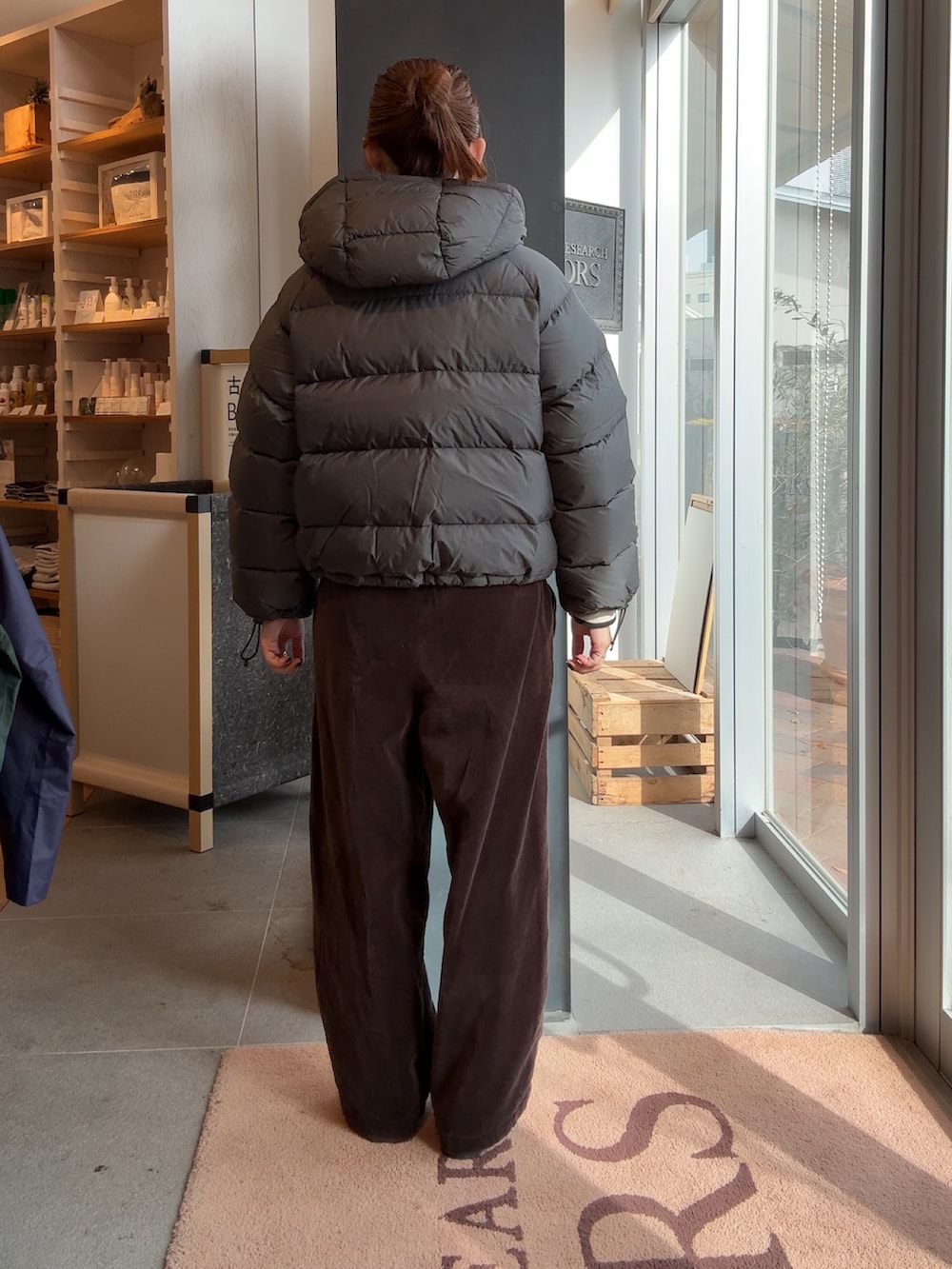 グレー系のダウンジャケット/コート、ブラウン系のその他パンツを着用したレディースの冬コーディネートの2枚目の写真