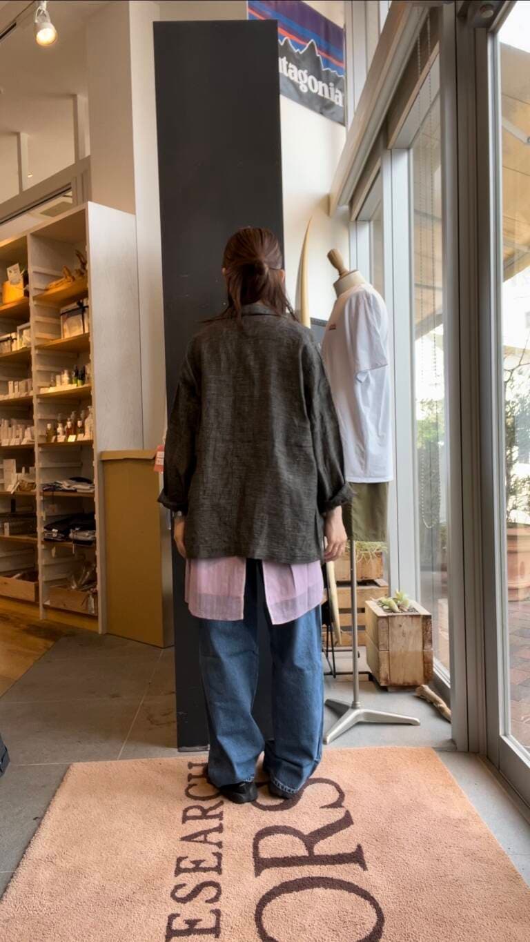 ブルー系のデニムパンツ、パープル系のキャミソール、ブラック系のテーラードジャケットを着用したレディースの夏コーディネートの3枚目の写真