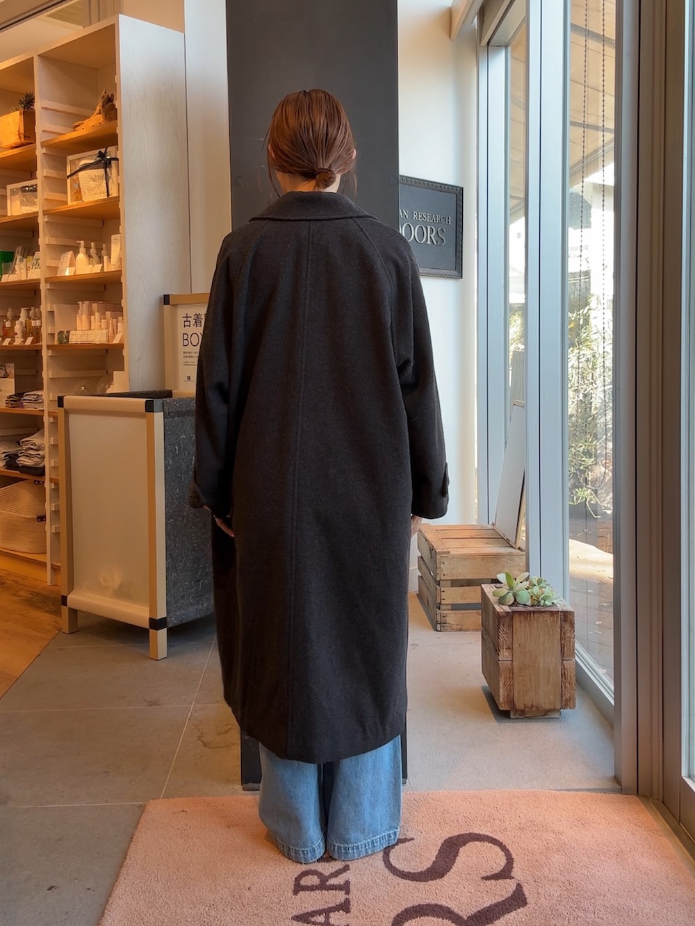 グレー系のその他アウター、レッド系のTシャツ/カットソー、ブルー系のデニムパンツを着用したレディースの冬コーディネートの2枚目の写真