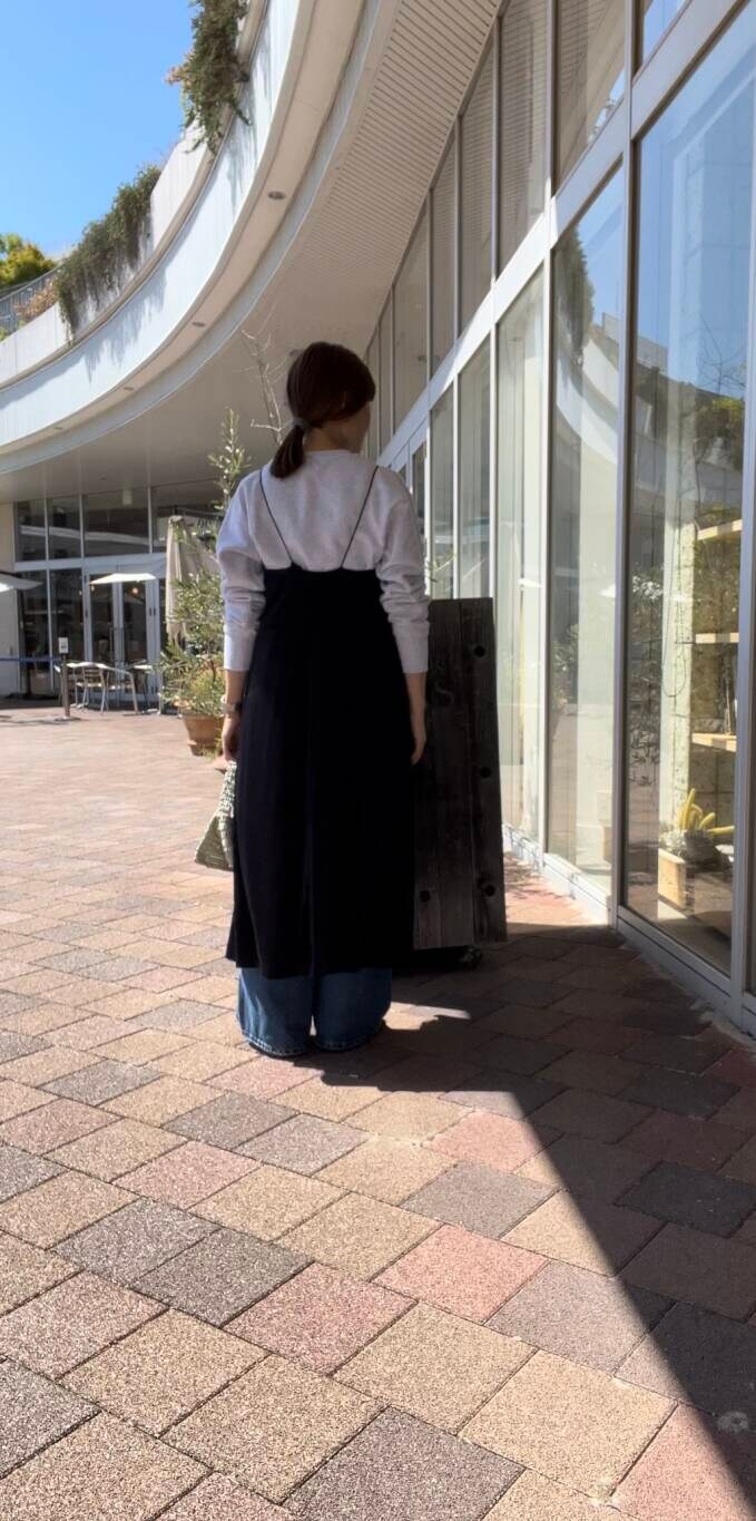 ゴールド系のハンドバッグ、ブルー系のデニムパンツ、グレー系のTシャツ/カットソーを着用したレディースの秋コーディネートの2枚目の写真