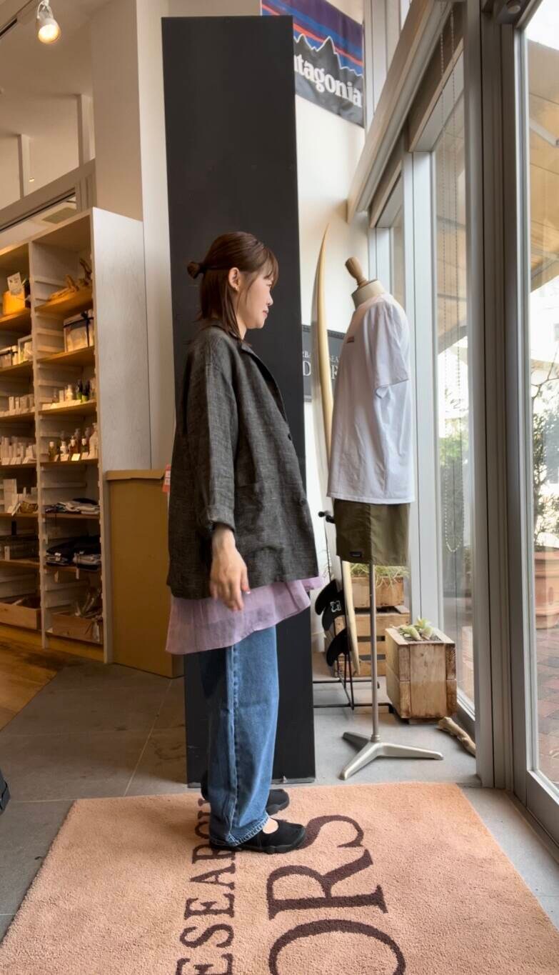 ブルー系のデニムパンツ、パープル系のキャミソール、ブラック系のテーラードジャケットを着用したレディースの夏コーディネートの2枚目の写真