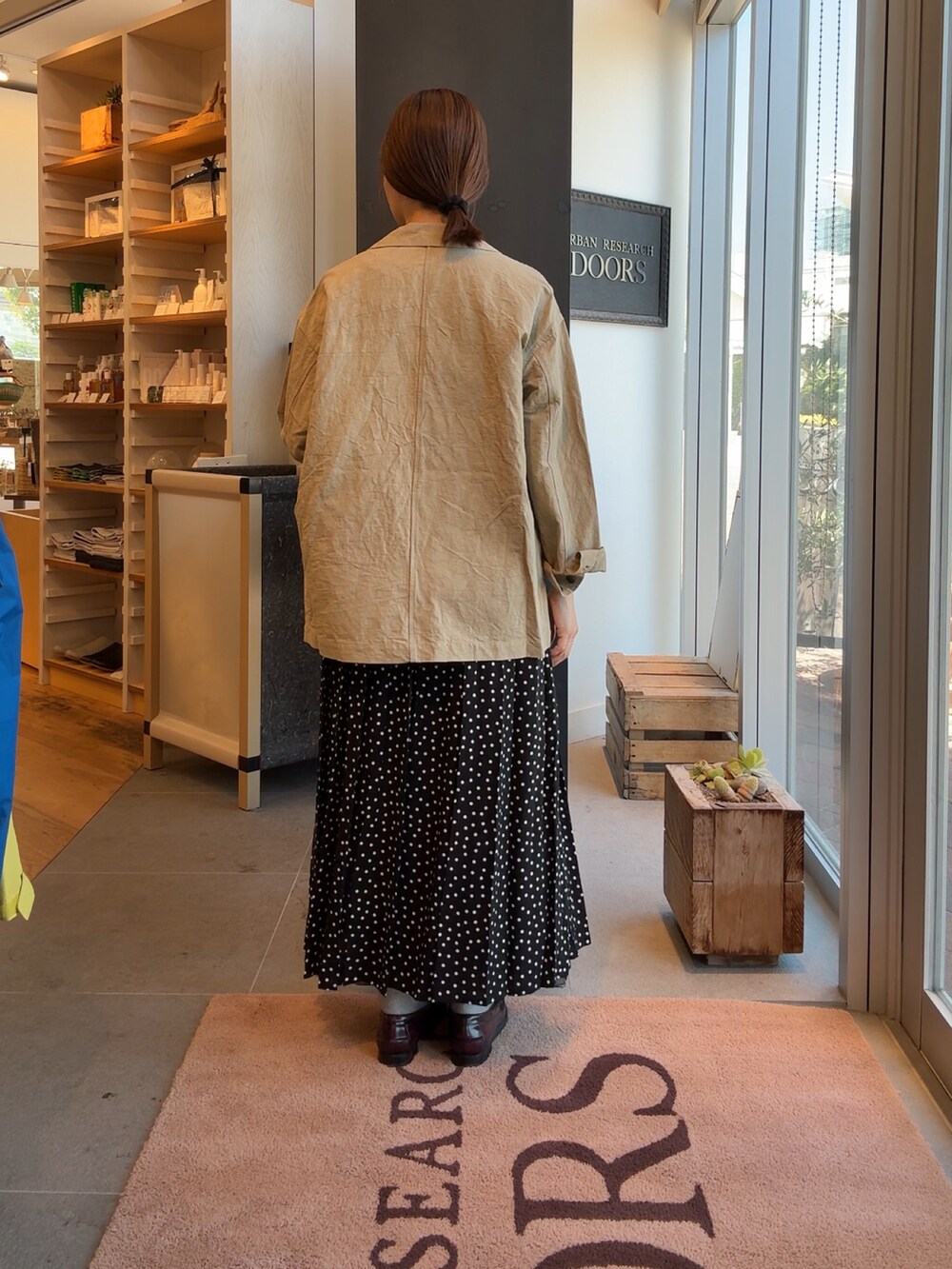 ベージュ系のその他アウター、ブラック系のスカートを着用したレディースの秋コーディネートの2枚目の写真