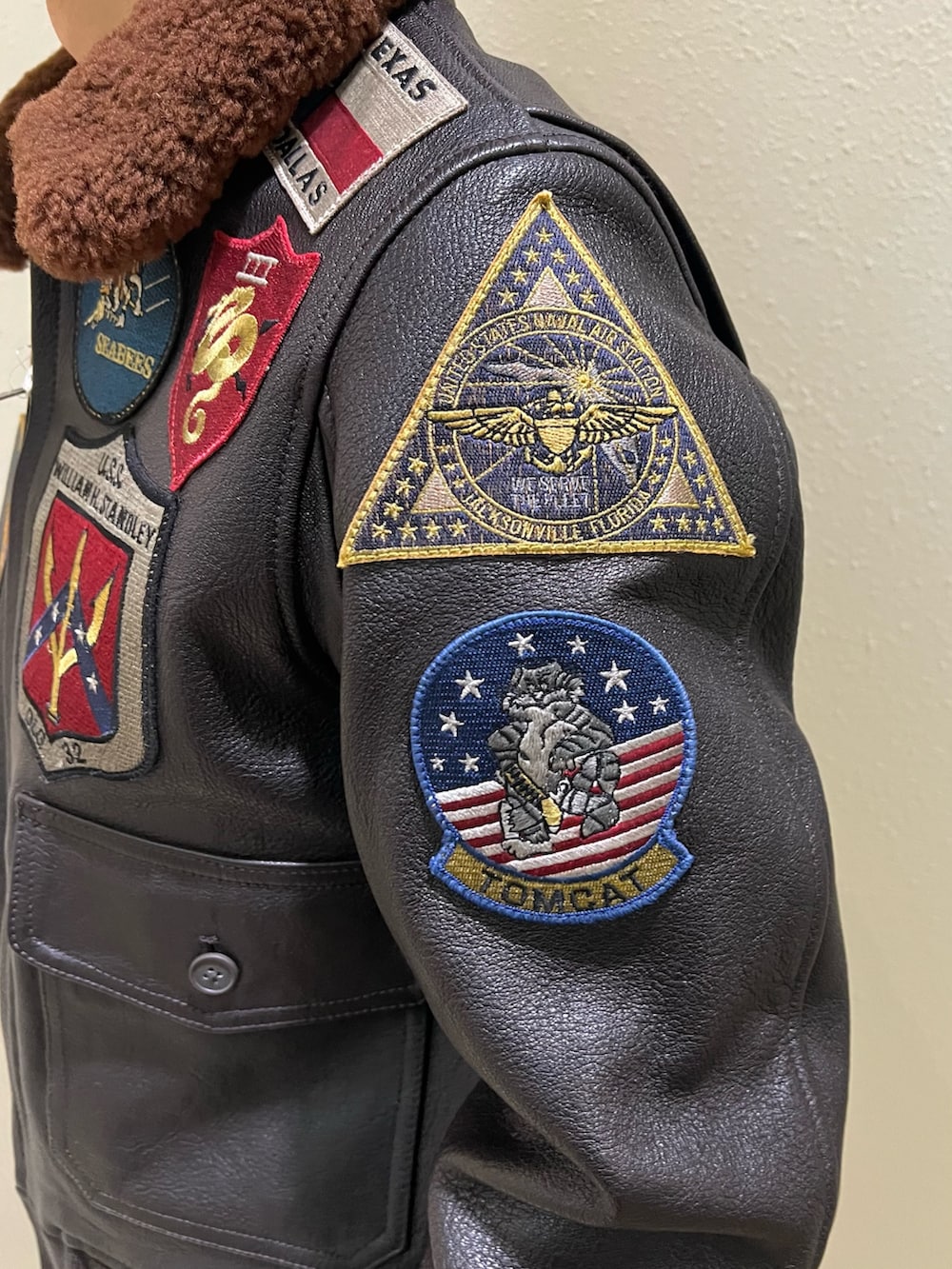 ブラウン系のミリタリージャケット、ホワイト系のTシャツ/カットソー、ブラック系のブーツを着用したメンズの冬コーディネートの4枚目の写真