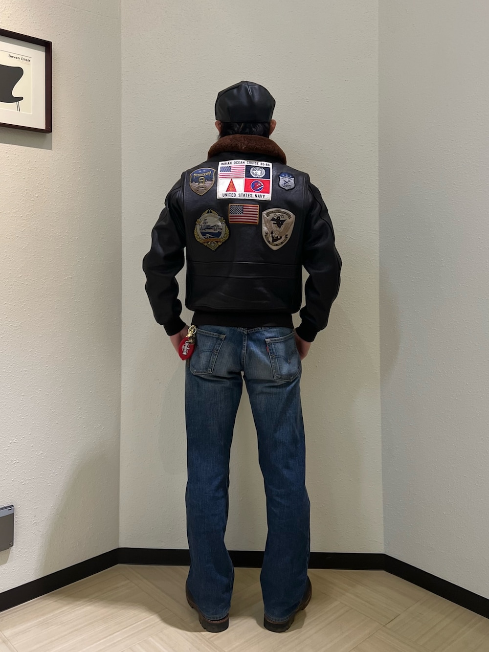 ブラウン系のミリタリージャケット、ホワイト系のTシャツ/カットソー、ブラック系のブーツを着用したメンズの冬コーディネートの2枚目の写真