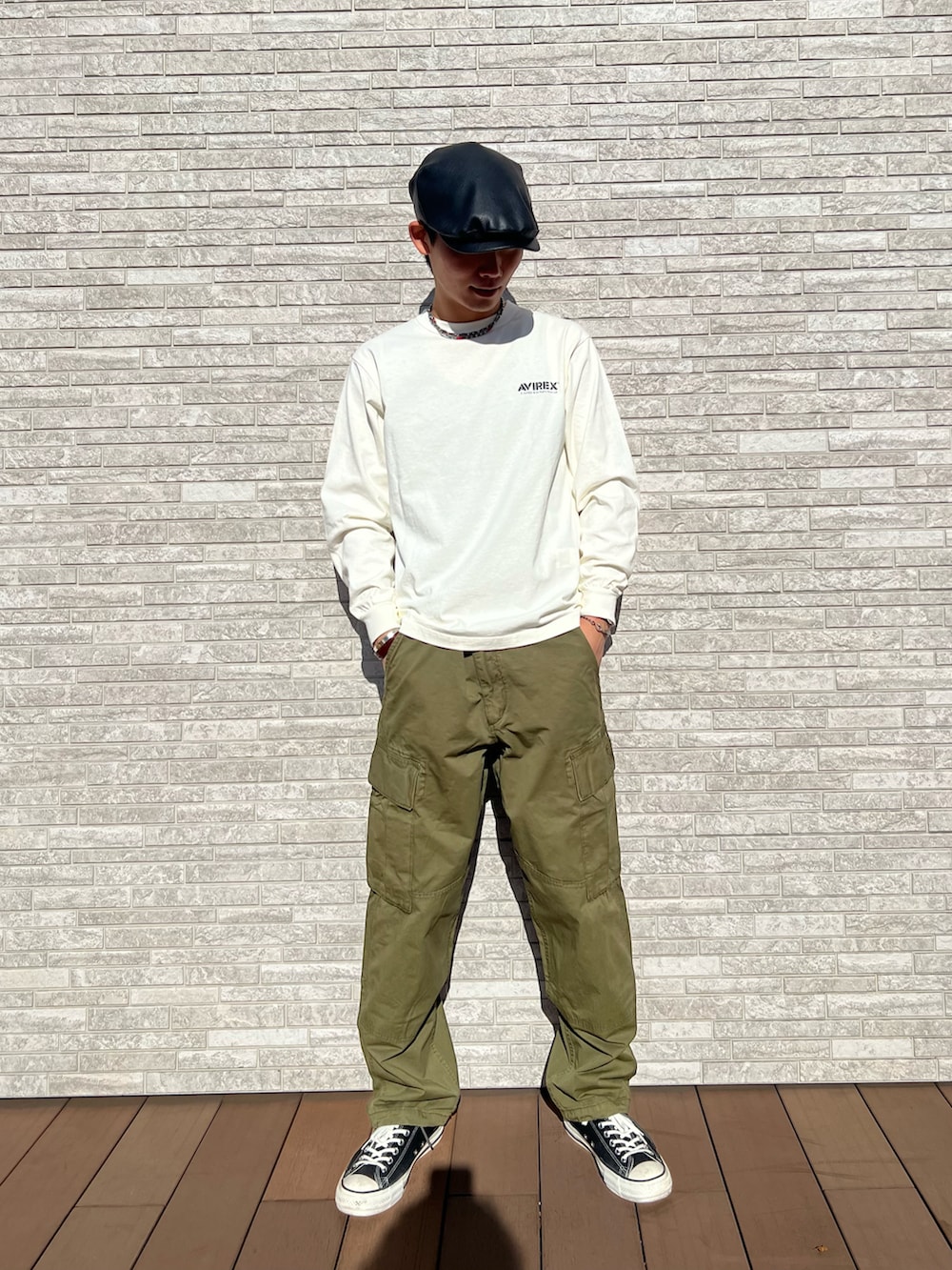 ホワイト系のTシャツ/カットソー、グリーン系のカーゴパンツ、ブラウン系のハンチング/ベレー帽を着用したメンズの冬コーディネートの2枚目の写真
