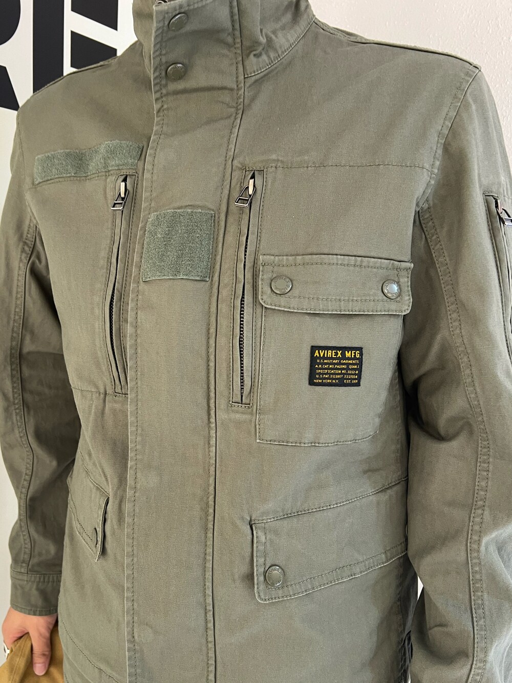 グリーン系のパンツ、グリーン系のジャケット/アウター、ブラック系のキャップを着用したメンズの夏コーディネートの4枚目の写真