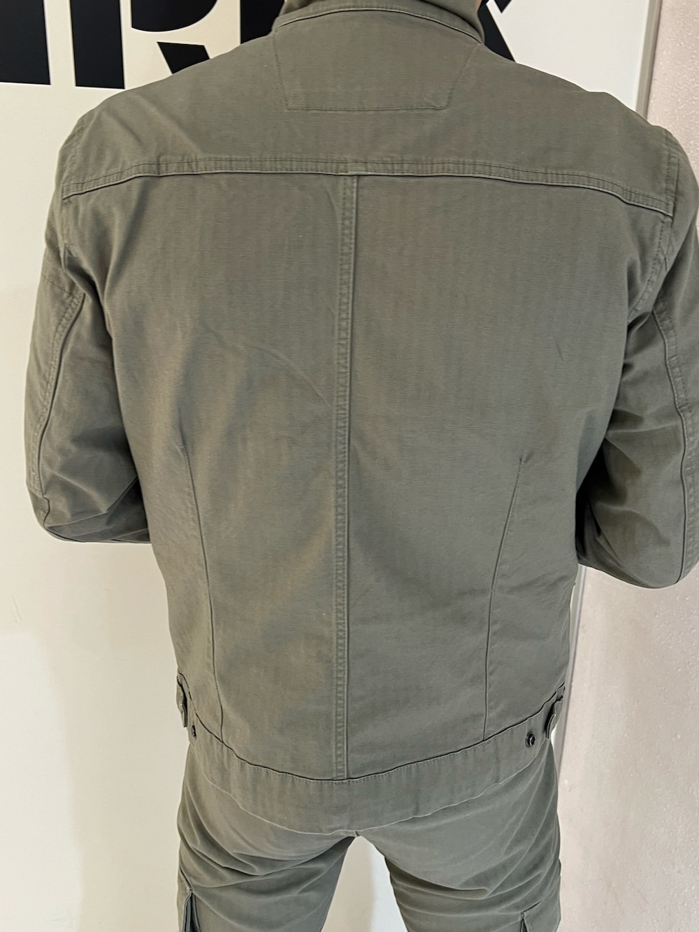 グリーン系のパンツ、グリーン系のジャケット/アウター、ブラック系のキャップを着用したメンズの夏コーディネートの3枚目の写真