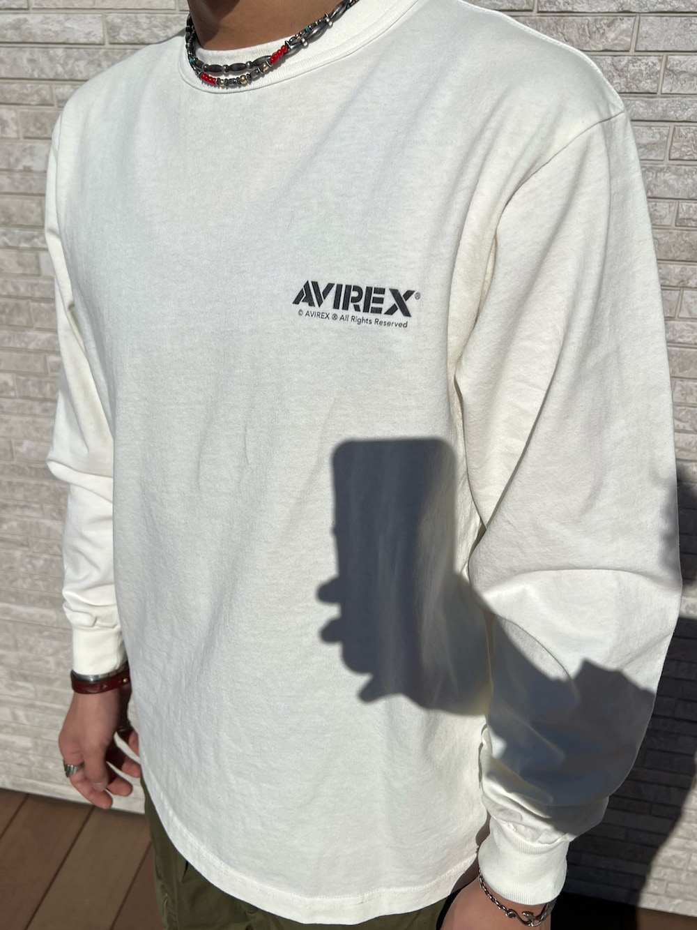 ホワイト系のTシャツ/カットソー、グリーン系のカーゴパンツ、ブラウン系のハンチング/ベレー帽を着用したメンズの冬コーディネートの4枚目の写真