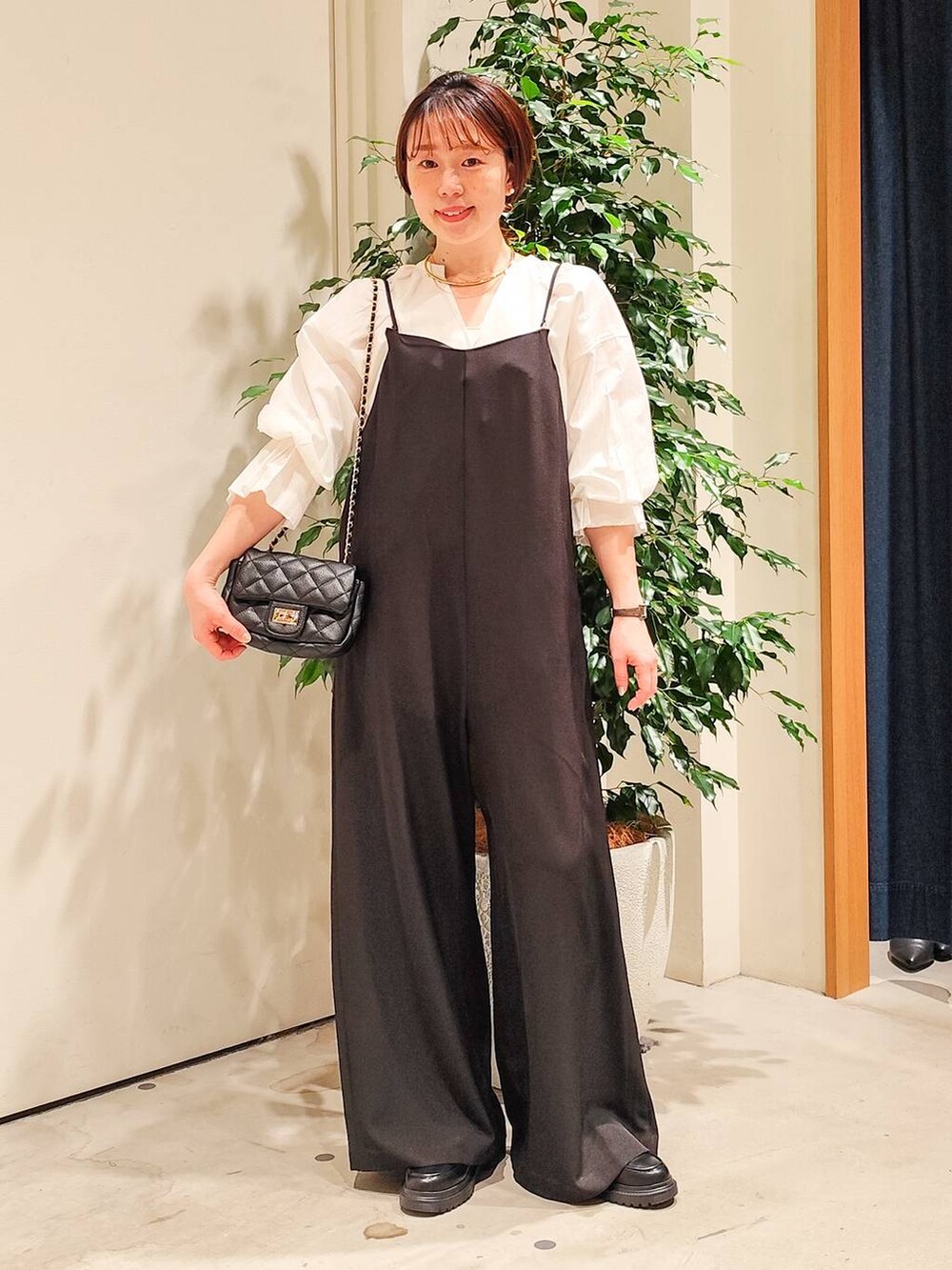 ホワイト系のシャツ/ブラウス、ホワイト系のキャミソール、ブラック系のつなぎ/オールインワンを着用したレディースの冬コーディネートの2枚目の写真