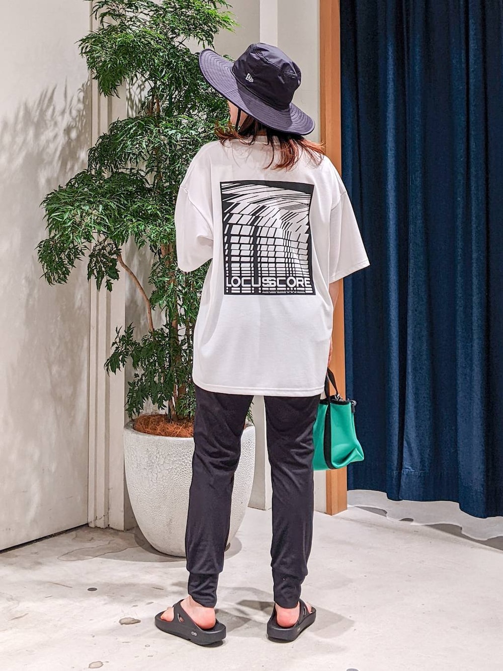 グリーン系のショルダーバッグ、ブラック系のその他パンツ、ホワイト系のTシャツ/カットソーを着用したレディースの春コーディネートの3枚目の写真