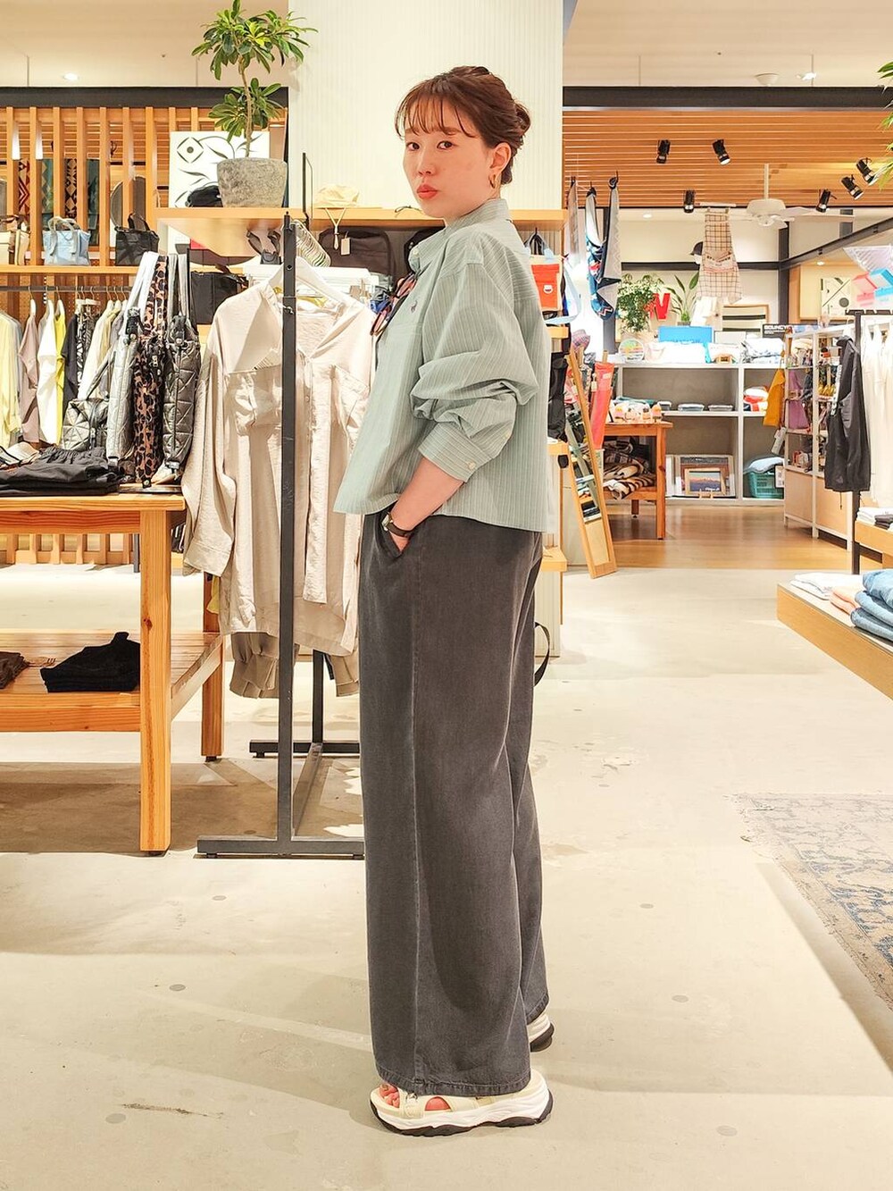 グリーン系のシャツ/ブラウス、グレー系のバックパック/リュック、ホワイト系のサンダルを着用したレディースの春コーディネートの3枚目の写真