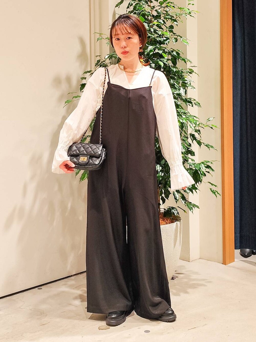 ホワイト系のシャツ/ブラウス、ホワイト系のキャミソール、ブラック系のつなぎ/オールインワンを着用したレディースの冬コーディネートの3枚目の写真