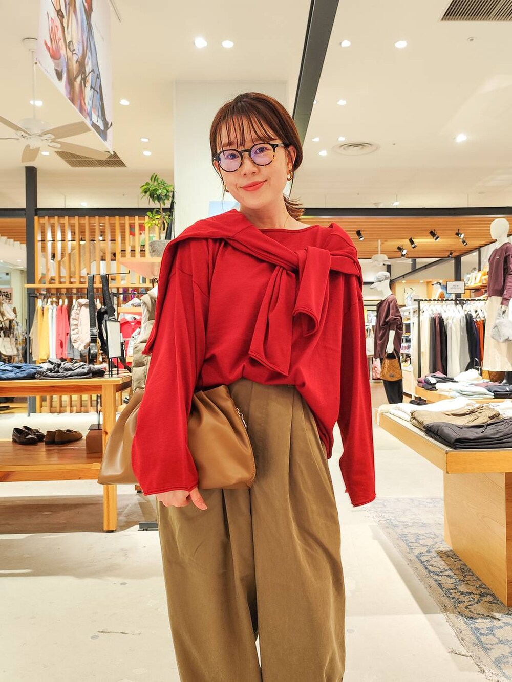 ブラウン系のモカシン/デッキシューズ、イエロー系のハンドバッグ、ブラウン系のストール/ショールを着用したレディースの秋コーディネートの4枚目の写真