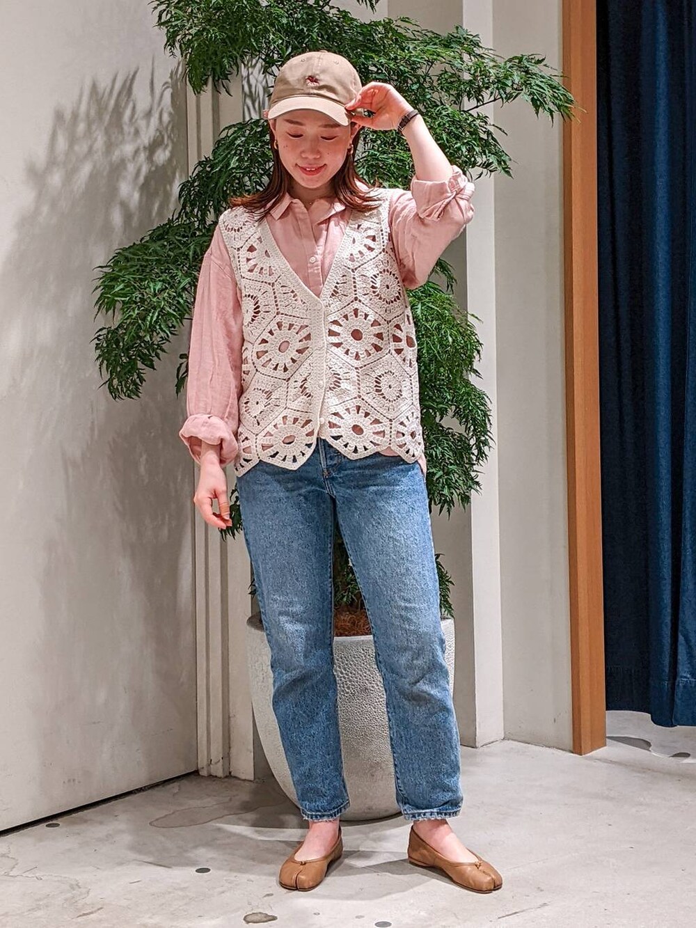 ベージュ系のベスト、ブルー系のデニムパンツ、ピンク系のシャツ/ブラウスを着用したレディースの春コーディネートの3枚目の写真