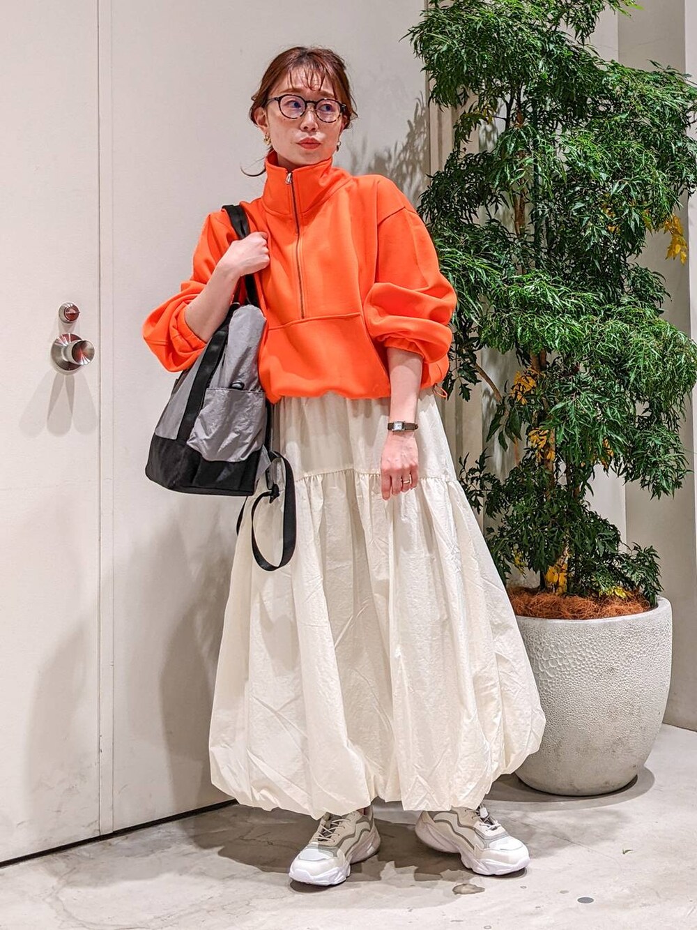 グレー系のバックパック/リュック、グレー系のスニーカー、ベージュ系のスカートを着用したレディースの冬コーディネートの2枚目の写真