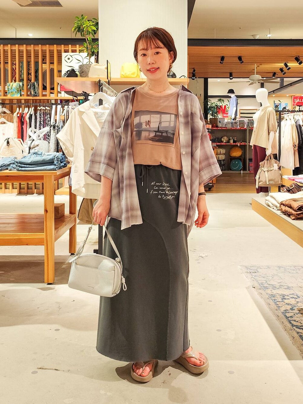 グレー系のシャツ/ブラウス、グレー系のスカート、シルバー系のショルダーバッグを着用したレディースの夏コーディネートの4枚目の写真