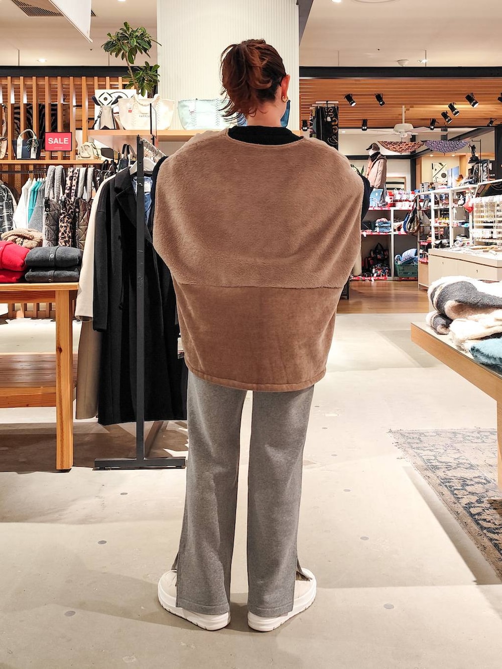 ホワイト系のスニーカー、グレー系のスウェットパンツ、ブルー系のニット/セーターを着用したレディースの冬コーディネートの4枚目の写真