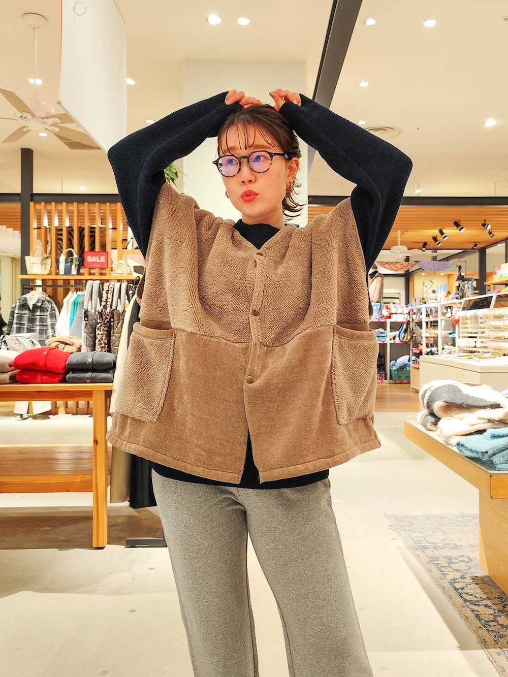 ホワイト系のスニーカー、グレー系のスウェットパンツ、ブルー系のニット/セーターを着用したレディースの冬コーディネートの2枚目の写真