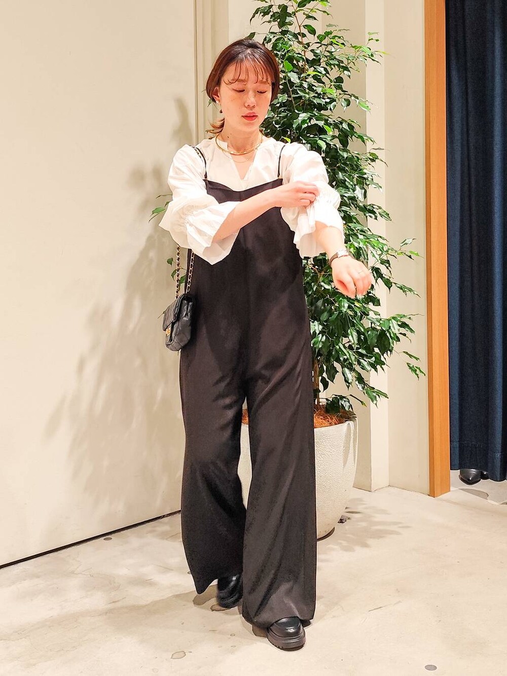 ホワイト系のシャツ/ブラウス、ホワイト系のキャミソール、ブラック系のつなぎ/オールインワンを着用したレディースの冬コーディネートの5枚目の写真