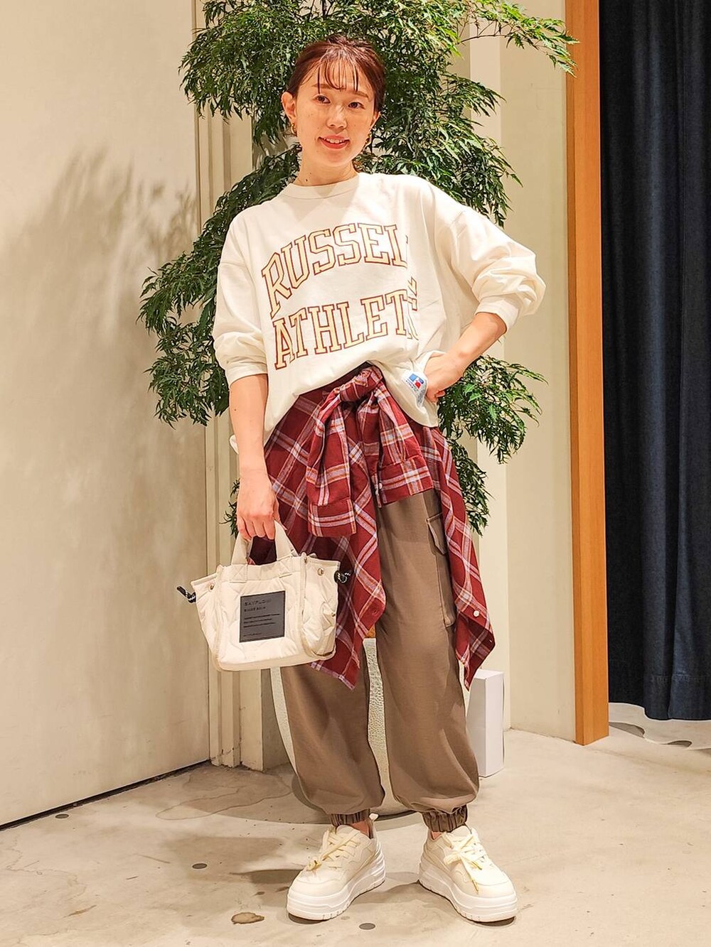 ホワイト系のショルダーバッグ、レッド系のシャツ/ブラウス、ブラウン系のカーゴパンツを着用したレディースの秋コーディネートの2枚目の写真