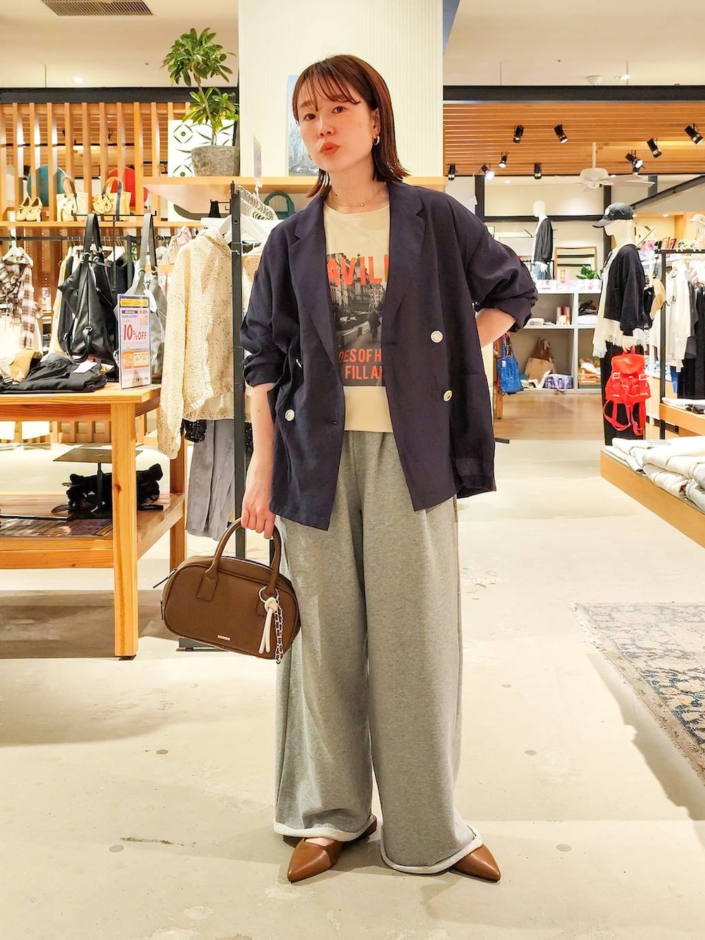 ベージュ系のTシャツ/カットソー、ブラウン系のパンプス、ブラウン系のハンドバッグを着用したレディースの春コーディネートの2枚目の写真