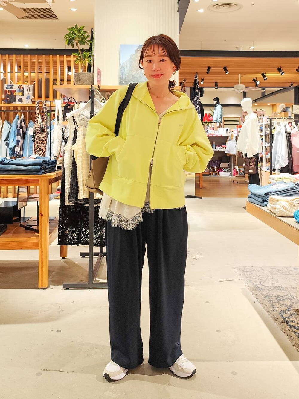 ベージュ系のキャミソール、イエロー系のパーカー、ブルー系のその他パンツを着用したレディースの冬コーディネートの6枚目の写真