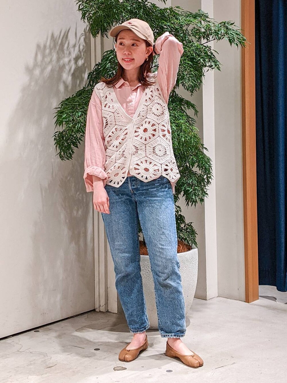 ベージュ系のベスト、ブルー系のデニムパンツ、ピンク系のシャツ/ブラウスを着用したレディースの春コーディネートの2枚目の写真