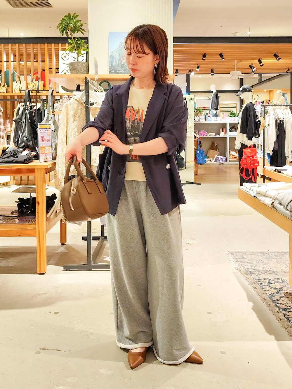 ベージュ系のTシャツ/カットソー、ブラウン系のパンプス、ブラウン系のハンドバッグを着用したレディースの春コーディネートの3枚目の写真