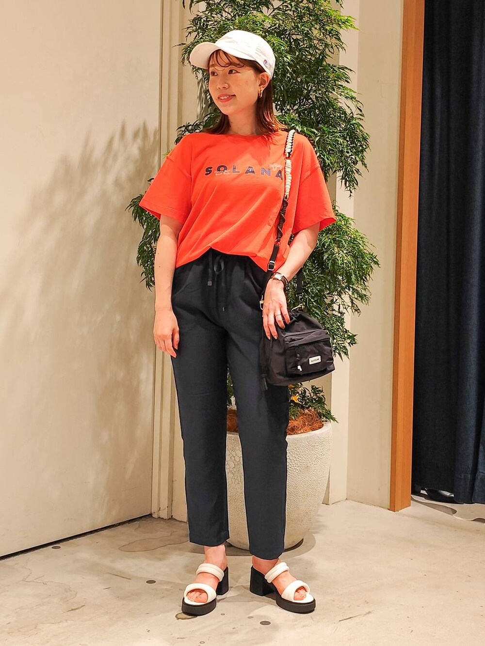 ホワイト系のサンダル、ブラック系のショルダーバッグ、ブルー系のその他パンツを着用したレディースの夏コーディネートの2枚目の写真