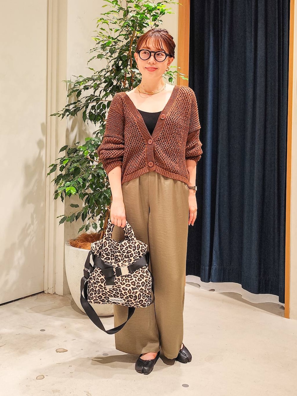 グリーン系のその他パンツ、ブラウン系のカーディガン/ボレロ、ゴールド系のチョーカーを着用したレディースの夏コーディネートの2枚目の写真