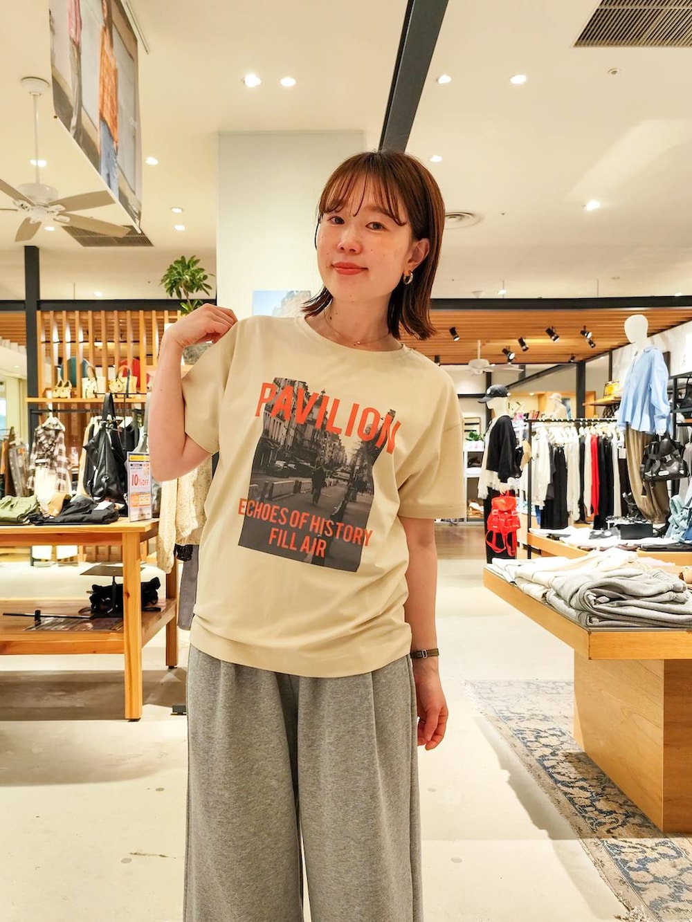 ベージュ系のTシャツ/カットソー、ブラウン系のパンプス、ブラウン系のハンドバッグを着用したレディースの春コーディネートの4枚目の写真