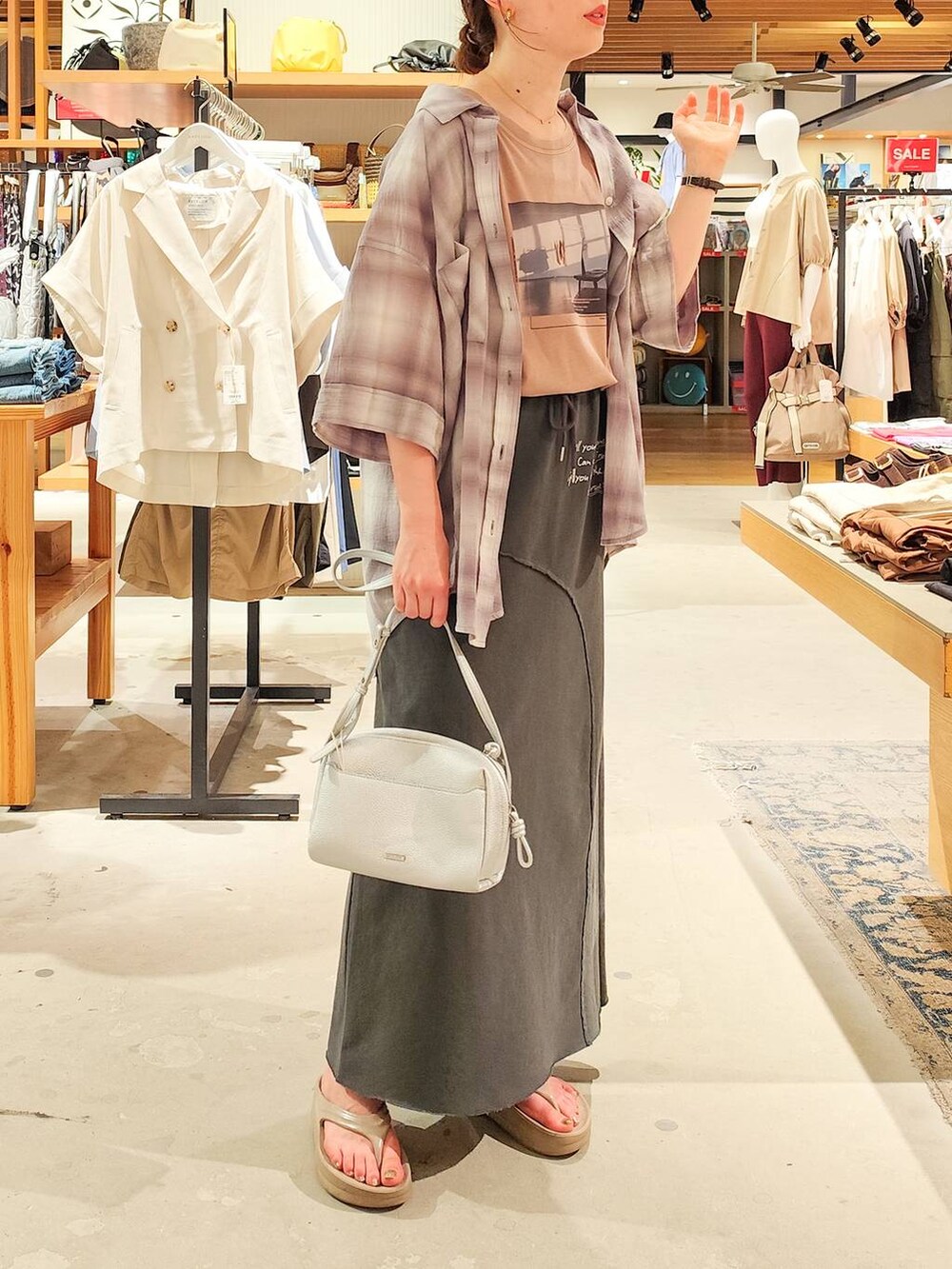 グレー系のシャツ/ブラウス、グレー系のスカート、シルバー系のショルダーバッグを着用したレディースの夏コーディネートの3枚目の写真