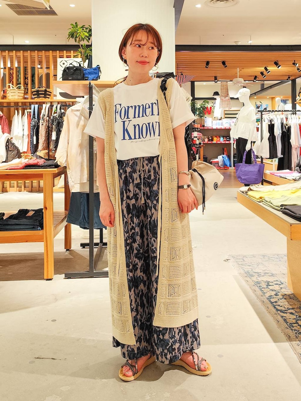 ホワイト系のTシャツ/カットソー、ベージュ系のその他パンツ、ブラック系のサンダルを着用したレディースの夏コーディネートの2枚目の写真