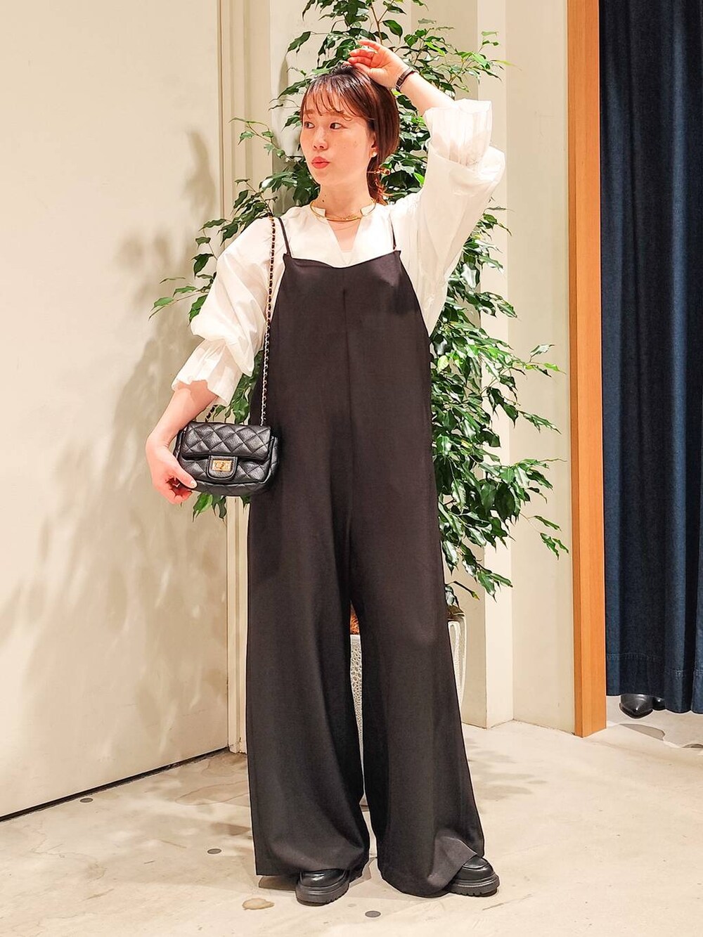 ホワイト系のシャツ/ブラウス、ホワイト系のキャミソール、ブラック系のつなぎ/オールインワンを着用したレディースの冬コーディネートの4枚目の写真