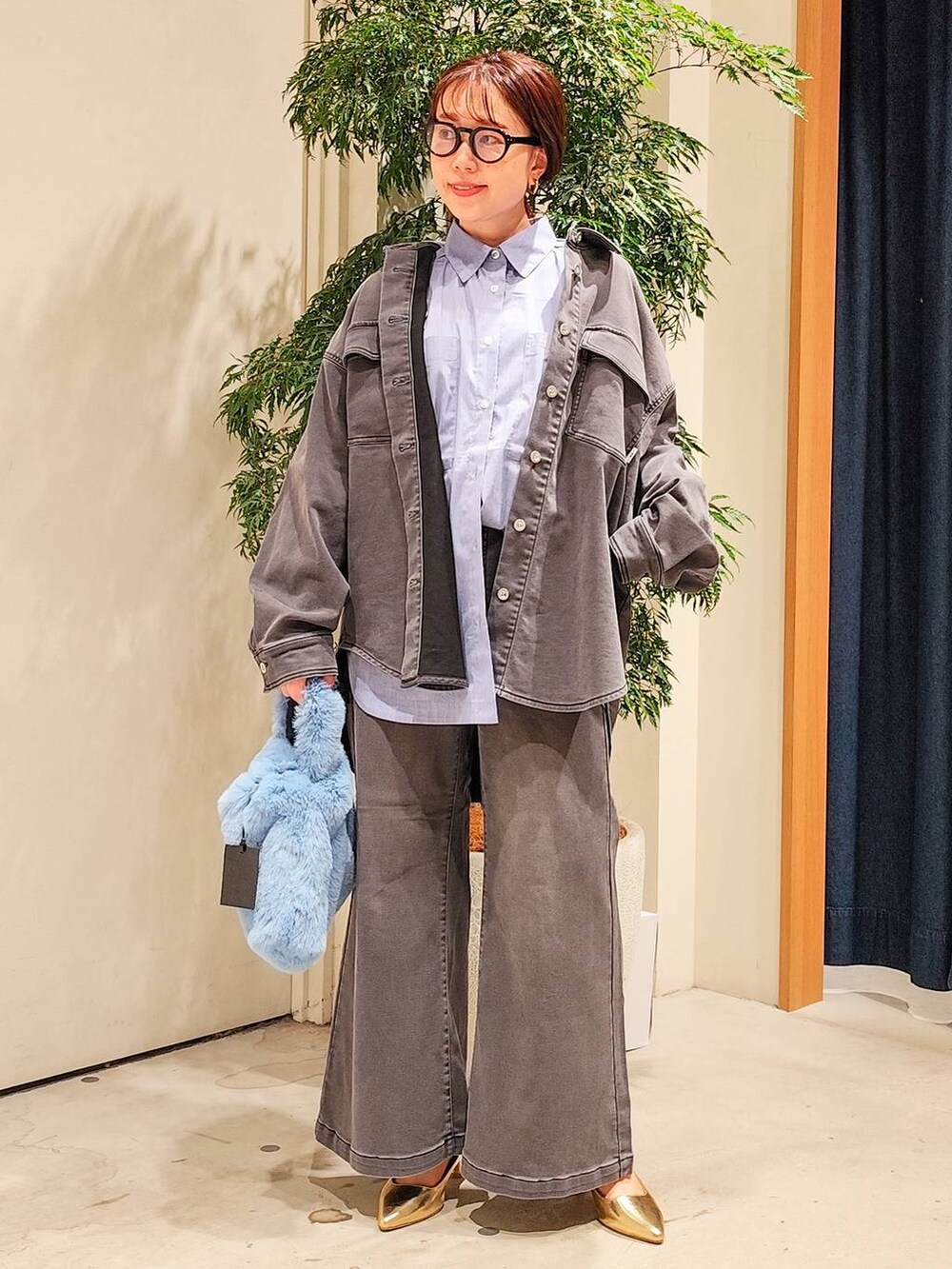 ブルー系のハンドバッグ、ブルー系のシャツ/ブラウス、ブラック系のシャツ/ブラウスを着用したレディースの秋コーディネートの4枚目の写真