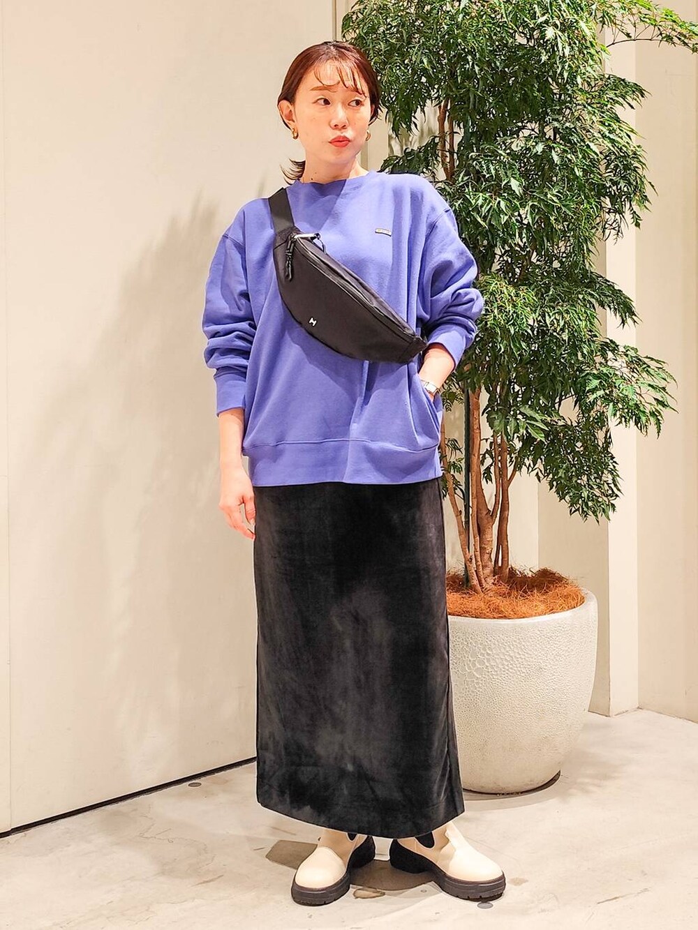 ブラック系のボディバッグ/ウエストポーチ、ブラック系のスカート、ホワイト系のブーツを着用したレディースの秋コーディネートの2枚目の写真